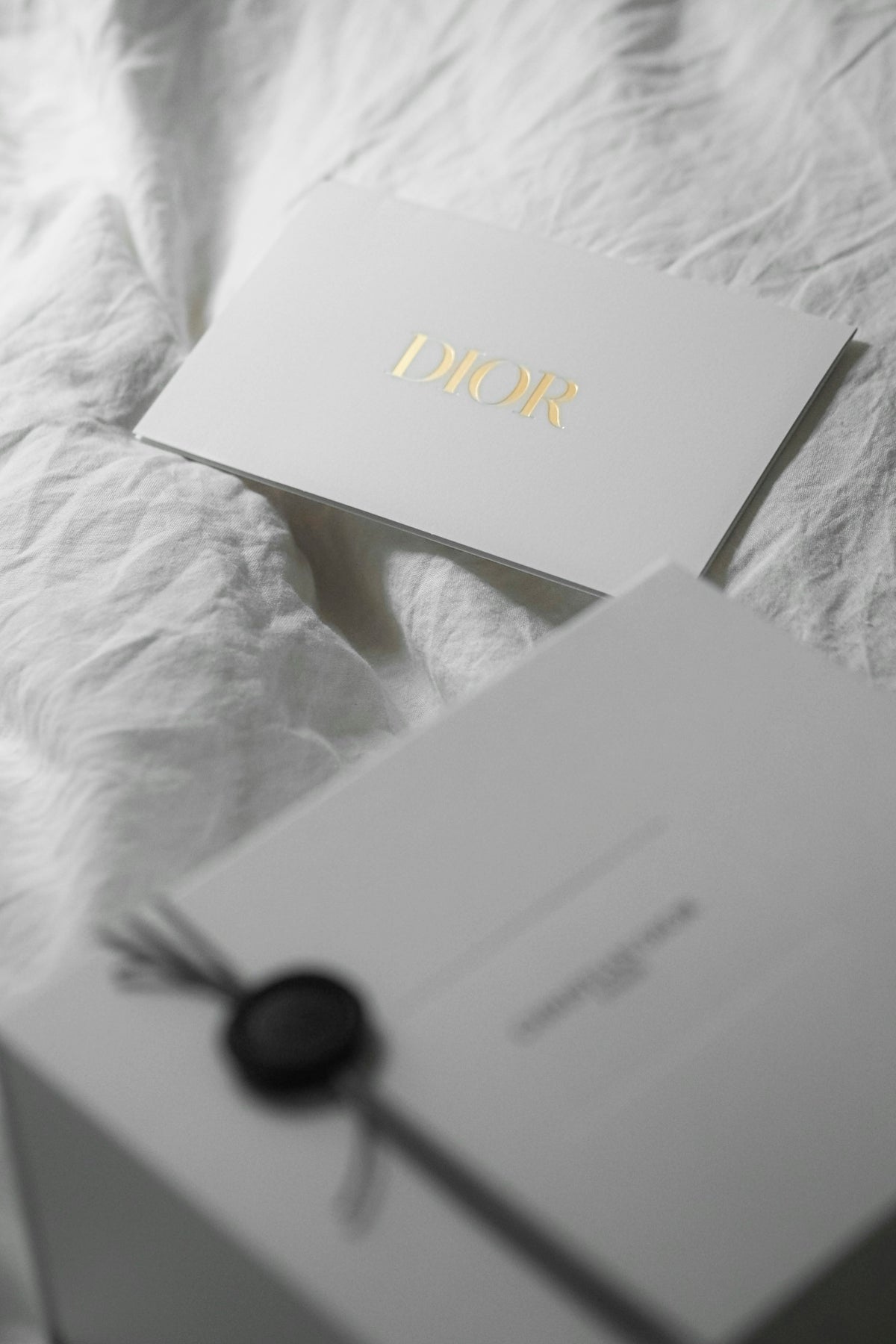 Dior card and gift box on white fabric